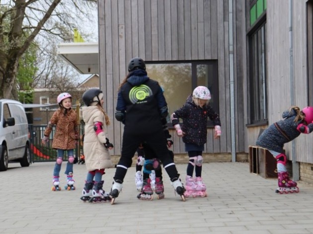 Skateclinic op het IKC in Kloetinge - trainer met kinderen
