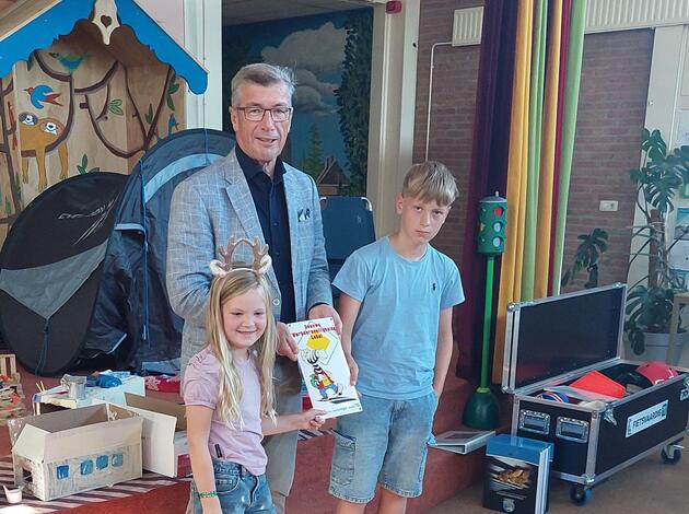 uitreiking muurbord van wethouder aan kinderen