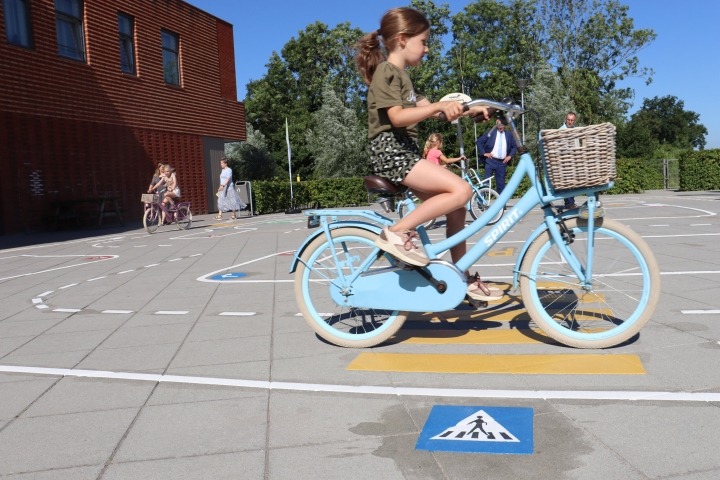 meisje op fiets op verkeersplein