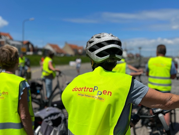Deelnemer met Doortrappen hesje en helm op