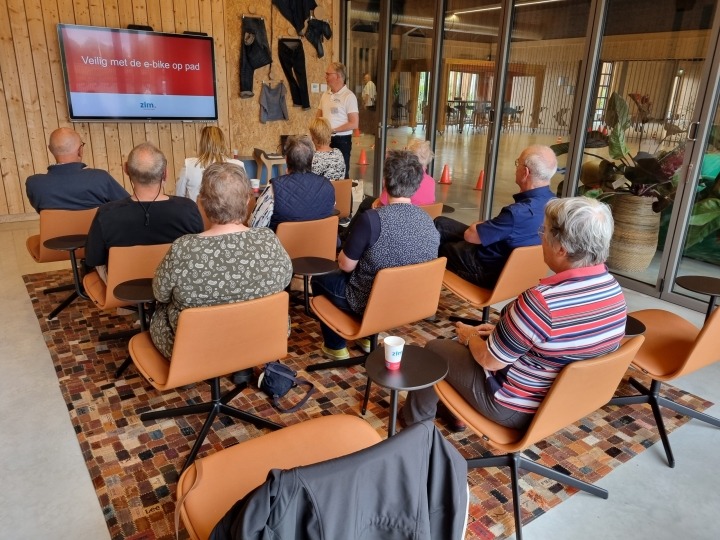 overzicht deelnemers die luisteren naar presentatie