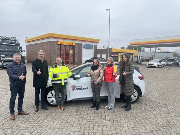 Organisatoren wasstraatactie en gedeputeerde bij auto voor wasstraat