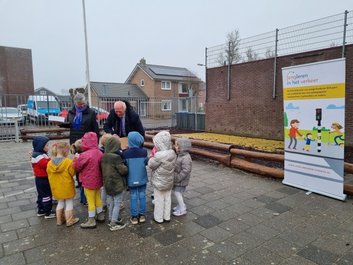 Wethouder en peuters op schoolplein