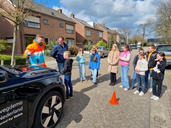 Leerlingen en instructeur bij auto tijdens remwegdemo