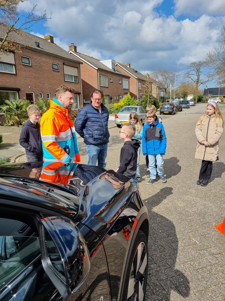 Leerlingen en instructeur bij auto
