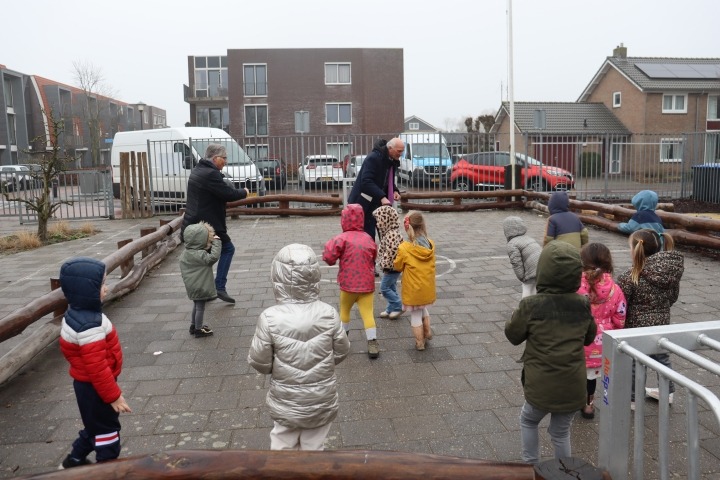 Peuters en wethouder op schoolplein