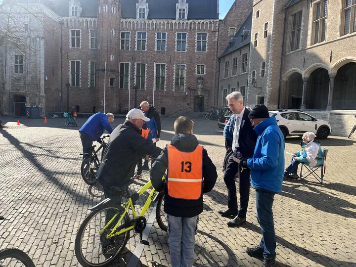 Gedeputeerde kijkt toe bij fietsenkleuring op abdijplein