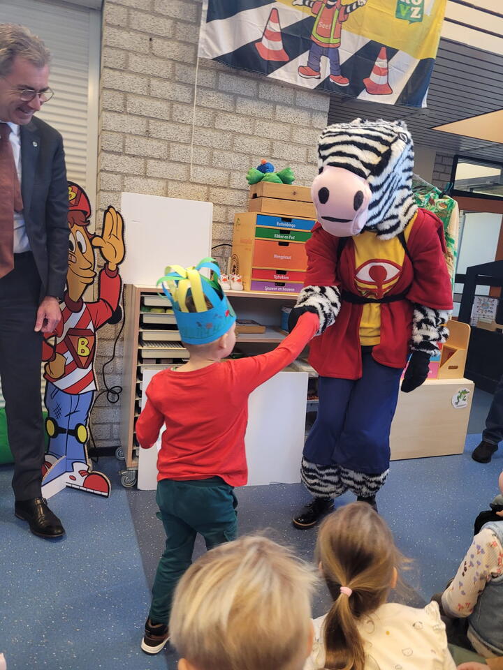 Seef de zebra geeft leerling een hand