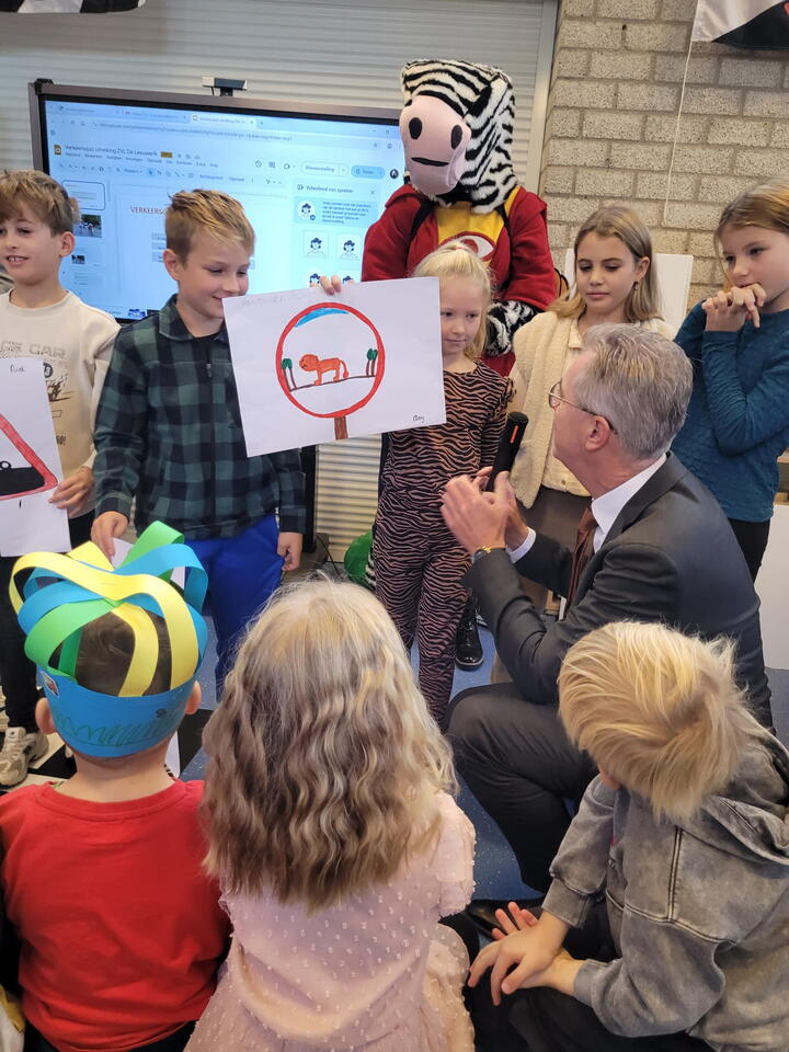 Gedeputeerde bekijkt tekeningen van leerlingen