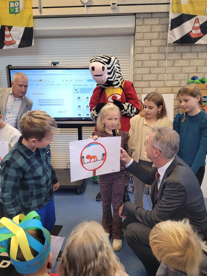 Gedeputeerde bekijkt tekening met leerling