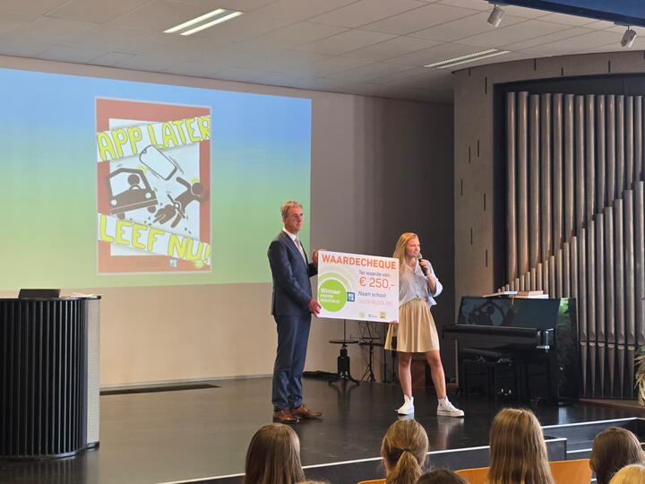 Twee personen houden de cheque omhoog