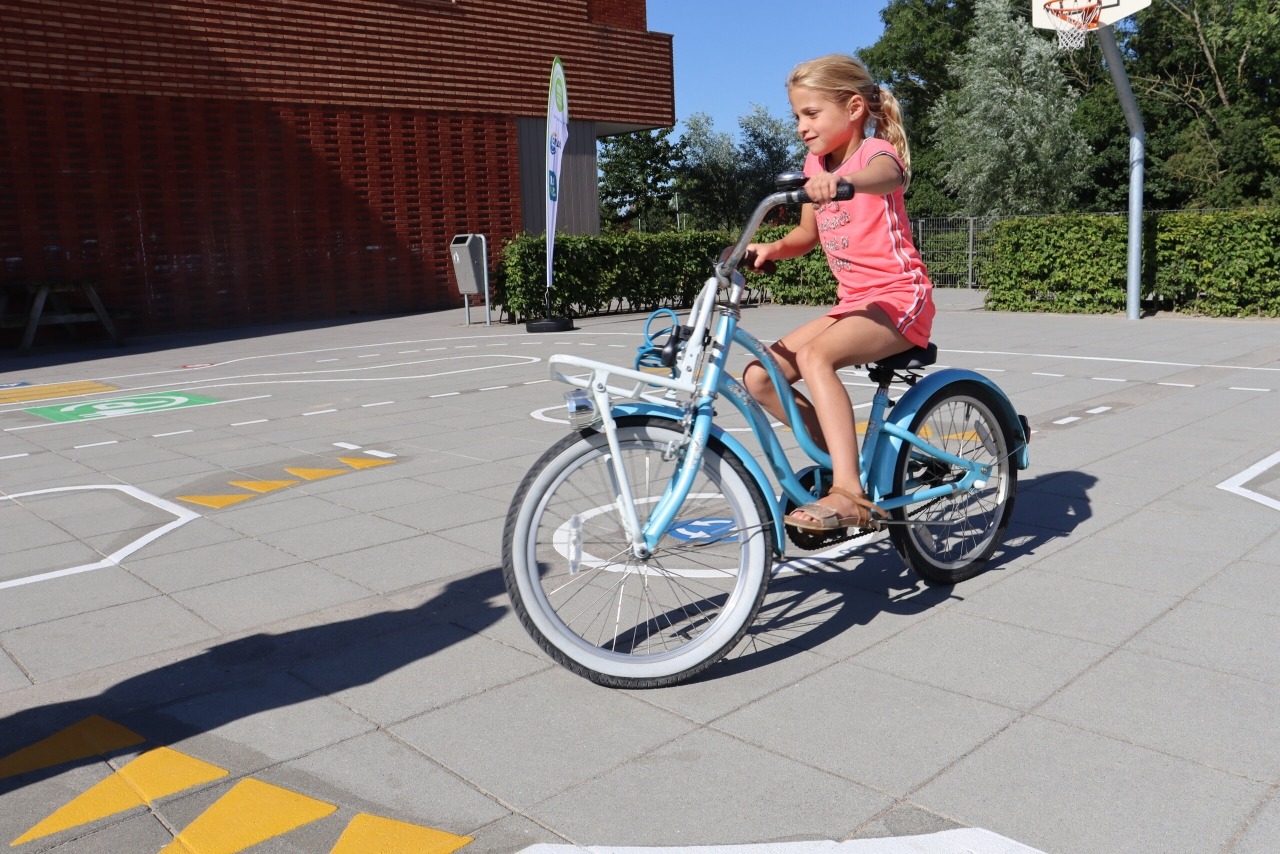 Meisje op fiets op verkeersplein