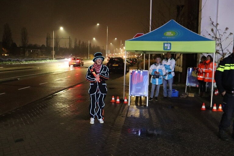 Lempke persoon in verlicht pak bij fietsverlichtingsactie