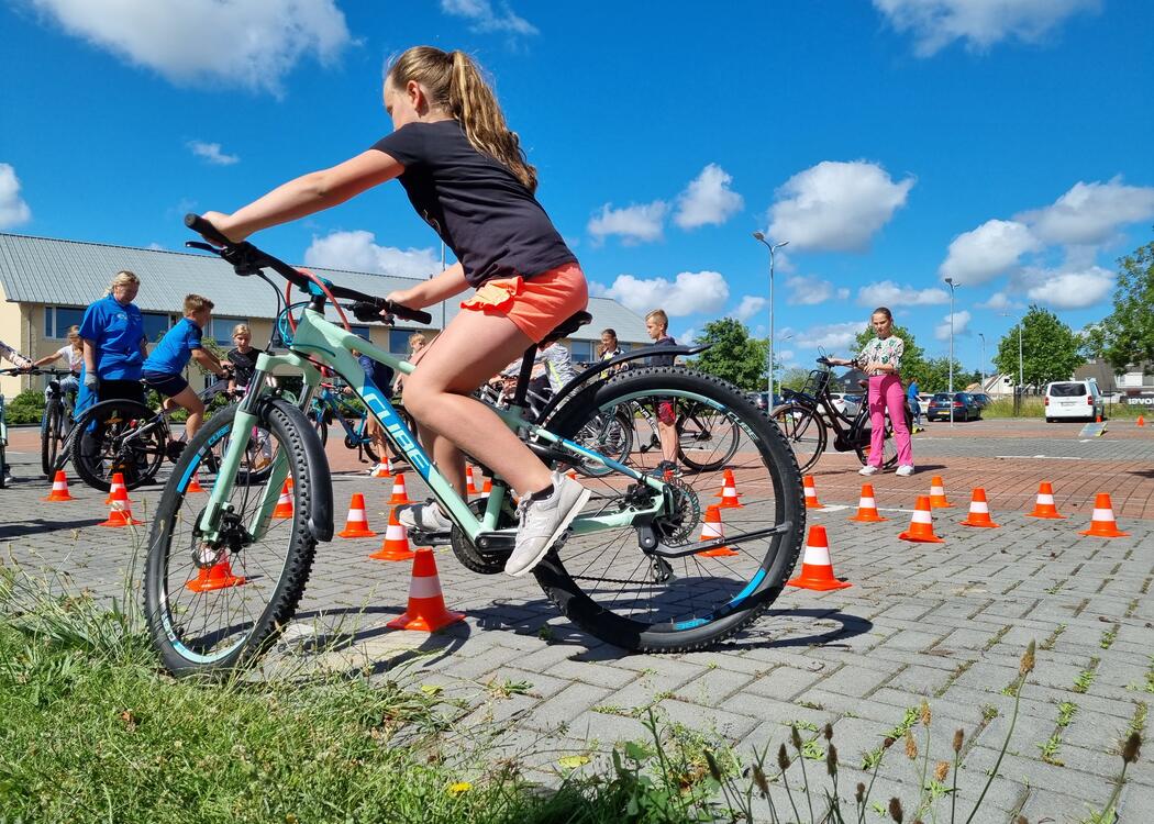 Leerling rijdt op fiets over hindernis tijdens Fietsmasters