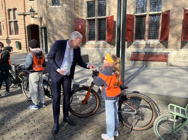 Gedeputeerde  Harry van der Maas geeft leerling eensleutelhanger