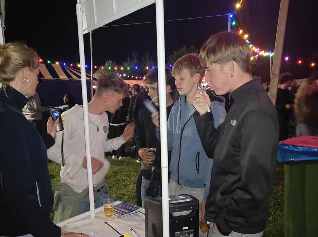 Bezoekers van Bigfest bezig met blaastest bij campagnekraam